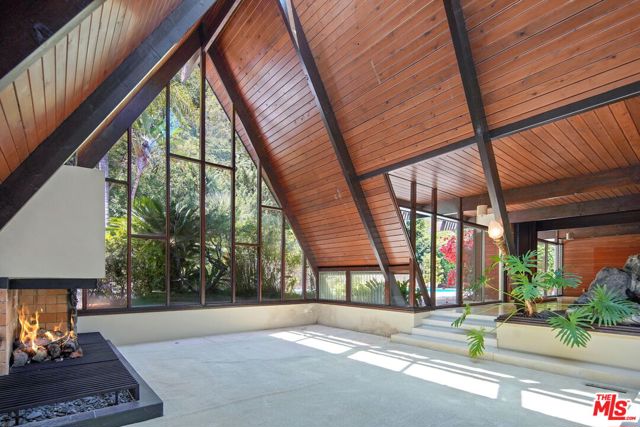 First celebrated in the pages of Architectural Digest in 1965, this midcentury A-frame masterpiece is now on the market and poised for its next chapter. This architectural refuge, in harmony with nature, was built in 1958 by the current owner and has been enjoyed by them since. Restore the residence to its former glory or reimagine and refurbish to create a modern paradise optimized for today's contemporary lifestyle. This very large flat pad is located on a cul-de-sac just outside of Beverly Hills city proper. Having traveled often to Hawaii, the owners "endeavored to recreate an atmosphere of island living," wrote the AD staff writer. "Landscaping with volcanic rock and trickling waterfalls among lush foliage lends a tropical aura that continues inside the house as well. Natural materials of wood and stone are used as structural forms. The exposed forms become, at the same time, both the architecture and the decoration." This is a rare opportunity to redevelop a unique and special property rich in provenance, sited on a desirable street and just moments to the iconic flats of Beverly Hills, famed Rodeo Drive, and the Westside.