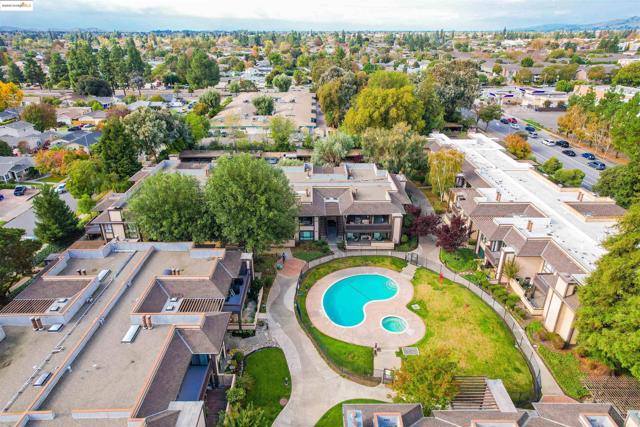 Aerial view of property and surrounding area featuring nearby suburban area