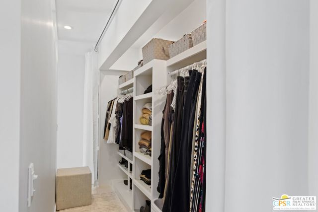 A walk-through closet provides plenty of storage, with both shelving and hanging rods.