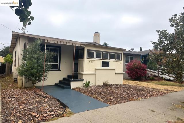 View of front of property featuring stucco siding and a chimney