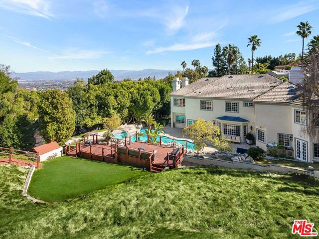 With far-reaching views over treetops and beyond, this updated, Traditional estate is located behind private gates in the highly desirable gated community of Mulholland Estates in Beverly Hills. The 5 bed/8 bath home beams with natural light and immediately showcases sky high, vaulted ceilings and a striking crystal chandelier upon entry into the grand foyer. A bright, open floor plan leads into the formal living room with fireplace and floor-to-ceiling French Doors opening to the expansive front patio. The main floor also includes a cozy family room with built-in bar, formal dining room and chef's caliber kitchen complete with breakfast nook and top-of-the-line appliances. Upstairs, the primary bedroom is its own private suite - featuring a large balcony, fireplace lounge, sitting room, dual walk-in closets and 2 luxuriously-appointed bathrooms with vanity area.Outdoors is a tranquil retreat, surrounded by the privacy of mature California landscaping with ample room for entertaining, dining and relaxation. Includes an outdoor kitchen with BBQ and pizza oven, sparking pool with spa, large grassy backyard area and multiple viewing decks to take in the stellar views. Other notable features include 3-car garage with additional driveway parking, library-style office, gym, maid's room and laundry. Located in a top-rated school district with easy access to the Valley, Beverly Hills and Westside shopping, dining and nightlife.