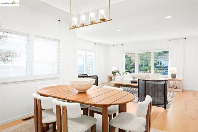 Dining room with light wood finished floors and recessed lighting