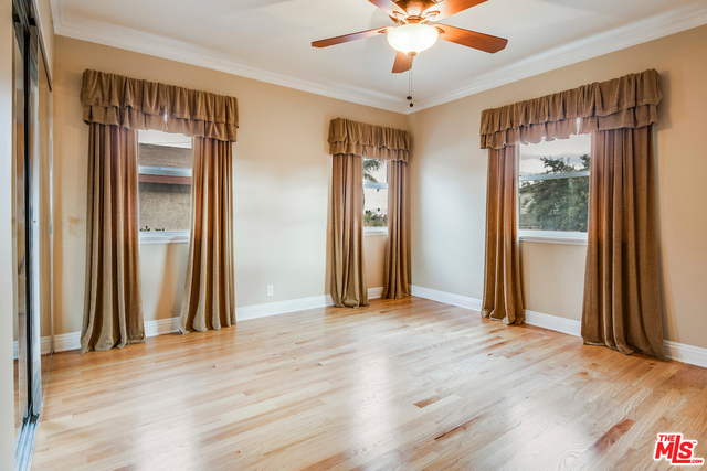 st bedroom wi ceiling fan, mirrored closet doors and several windows