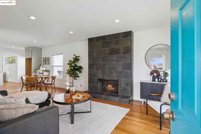 Living room featuring light wood-style flooring, a tile fireplace, and recessed lighting
