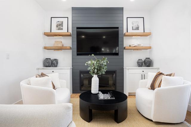 Large living room and entry area, custom fireplace with built in cabinets and floating shelves