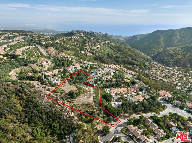 1445 El Bosque Court Pacific Palisades, California A sprawling hilltop property high above the Pacific Palisades offers a perfect canvas to create your dream estate. This once-in-a-lifetime opportunity combines two large neighboring lots atop the Highlands neighborhood, merging grand scale with natural charm. Situated at the end of a cul de sac, enter through the gated private long driveway lined by Cypress trees, leading to flat open space surrounded by nature - the Santa Monica Mountains and partial Pacific Ocean views. Included are plans for a 9,000 SF Steven Ehrlich designed modernist residence as well as an additional schematic plan from O&L Architects where one can build up to 18,000 SF. Close proximity to the Bel Air Bay Beach Club, Palisades Village, Malibu, and the beach. The neighboring property, 1458 Palisades Dr to be sold with the property, priced together at $4,900,000. APN: 4431-023-012.
