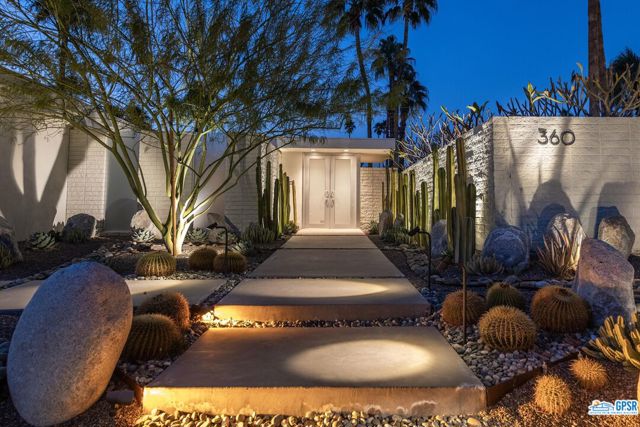 This late mid-century property completed in 1970 is one of the few that have ever become available in Old Las Palmas. From the street the interesting desertscape with sculpted metal borders was created by one of the sellers who is a designer himself and inspired by renowned Brazilian landscape architect Roberto Berle Marx. Walled and gated, the pedestrian entry gate leads to a front-loaded clover shaped pool and adjacent spa situated to drink in the glorious mountain views. Floor to ceiling windows cascade the common areas and open for fresh air and for taking in the surrounding mountains which become your living art. Double glass entry doors expose the poured terrazzo floors which are in much of the property. The step-down living room has wood floors with centered gas fireplace and beautiful built ins. To the West (protected by exterior rolling shutters) the magical garden and outdoor dining area are revealed. Great kitchen with prep sink and direct access to the exterior BBQ area, dining and various vignettes all with their own feeling of mystery and wonder. There are four bedroom suites (two currently being used as offices) and an oversized primary suite with incredible mountain views, a garden view shower and soaking tub with direct access to the shaded pool pavilion off the primary suite. Formal dining as well as a relaxation library area flanked with tile created by one of the sellers also directs you to an additional outdoor vignette. This property has a fantastic feeling and vibe all on its own and it is experienced right from the start from the street entry though the doors revealing a private understated and sophisticated sanctuary.