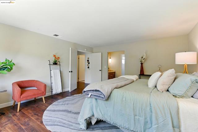 Bedroom with dark wood finished floors and ensuite bathroom