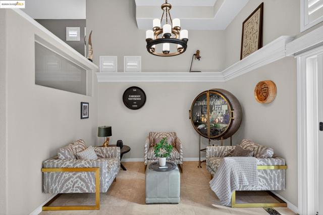 Living area featuring a chandelier, a high ceiling, and tile patterned flooring