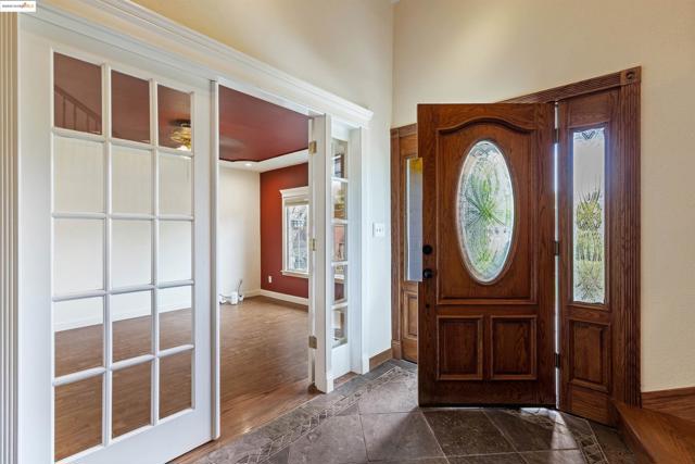 Foyer with ceiling fan and dark wood-style floors