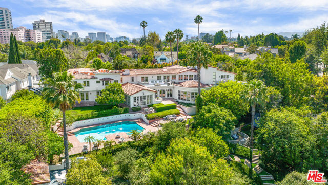 830 BIRCHWOOD Drive Los Angeles, California Centrally located on a desirable double lot in Little Holmby, this remarkable estate offers the best in modern living with beautiful golf course and city views. Off of a very private one way street, as if straight out of a magazine, this luxurious modern Spanish style residence is simply impeccable, from its spectacular facade and architectural features to the expansive layout with decadent details. Step inside the over 11,000-sq ft 5 bed (expandable to 7) and 11 bath interior where vast entertaining areas showcase volume ceilings soaring above a combination of stone and oak flooring. Adorning the foyer is a dramatic fireplace, a display nook, and graceful archways that greet you at every turn.Reclaimed beams add rustic elegance to the living room's vaulted wood ceilings, anchored by a stately fireplace and walls of French doors that access a few of the many outdoor areas.A wet bar and a stylish walk-in wine closet connect to the sunlit dining room that enjoys picturesque vistas framed by arched glass doors. Sure to delight the home chef, a contemporary kitchen has top of the line stainless steel appliances, sleek cabinetry, marble countertops, and an oversized four-seater island. A seamless open concept flow to the adjacent family room allows you to join in the fun while crafting your signature dishes.Nothing says "opulent" like your generously sized primary suite with its own fireplace, sitting area, dual walk-in closets, two en suites, steam shower, salon station, an infrared sauna, outdoor terrace, and adjoining gym. Explore the extensive grounds that treat you to a pool and spa with adjacent changing room, built-in BBQ kitchen, running track, half basketball court, fruit trees, rose garden andBarbara Butler-designed tree house, all surrounded by verdant landscaping. Other noteworthy items are a theater, arts and crafts room, game room, beautiful home office, incredible storage, covered verandas, and an attached 3-car garage. Searching for a grand estate unlike any other? Come take a tour to experience it all for yourself!
