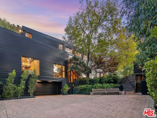 9560 Sherwood Forest Lane Beverly Hills, California With a long driveway approach, high ceilings & floor-to-ceiling glass to frame mountain views, this unparalleled residence is set back from the street on almost an acre of lush canyon & is a warm haven that celebrates its natural setting. Wood & stone are prominent design materials referencing the surrounding landscape, while offering pristine, one-of-a-kind interiors & consummate privacy. The entry foyer is highlighted by a tri-level cascading Koi pond & leads into the main living spaces, filling with natural light through elongated windows. The immaculate chef's kitchen w/butler's pantry, overlooks the canyon with a sleek palette of slate & marble. Mature landscaping surrounds the 5,245 SF, newly remodeled property - w/the addition of 1,000 SF secluded primary suite, along with 3 luxuriously-appointed guest beds - each w/their own distinct design. Enjoy the lush exterior from the expansive outdoor deck space, complete w/multiple lounge & entertainment areas, pool & detached library.