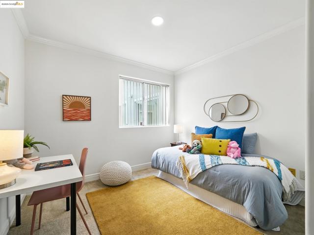 Carpeted bedroom with ornamental molding and a desk