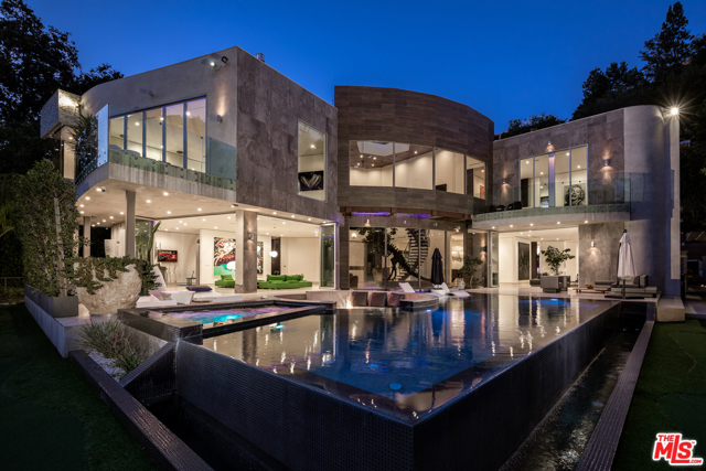 1006 CHANTILLY Road Los Angeles, California Modern architectural masterpiece in prime lower Bel Air. Nestled behind gates in a lush canyon setting, this exquisite contemporary is an entertainer's paradise w/over 10,000 SF of meticulously crafted living space. Enter the dramatic atrium complete w/curved staircase & soaring ceilings & experience an open-concept floor plan w/seamless integration of the indoors & outdoors. Highlights include a beautifully appointed chef's kitchen w/state of the art Miele appliances & LED lit kitchen countertop made of handblown Canadian glass. The master bedroom rivals the finest hotels, w/walls of glass & sumptuous spa-like bthrm. Entertain w/the 10-seat movie theater, billiard table, 200 bottle wine cellar, a exercise/steam rm. Outside, the grounds feature a cutting edge infinity pool, a water feature w/computerized rain bar & a sunken seating area w/fire-pit. Private & gated motor ct accommodates a dozen cars, w/3 car garage w/Tesla full house Battery back-up solar panels & additional guest house.