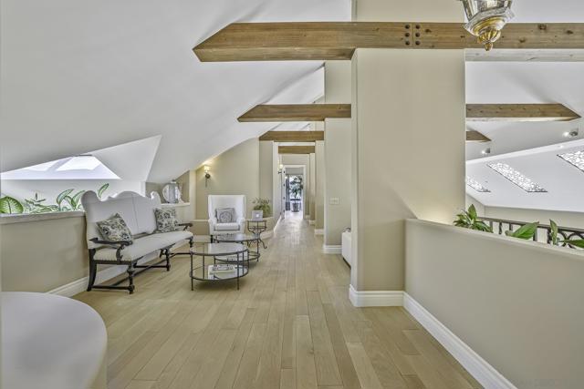 Upstairs hall with sitting areas feature wide plank oak floors and beautiful wood beams