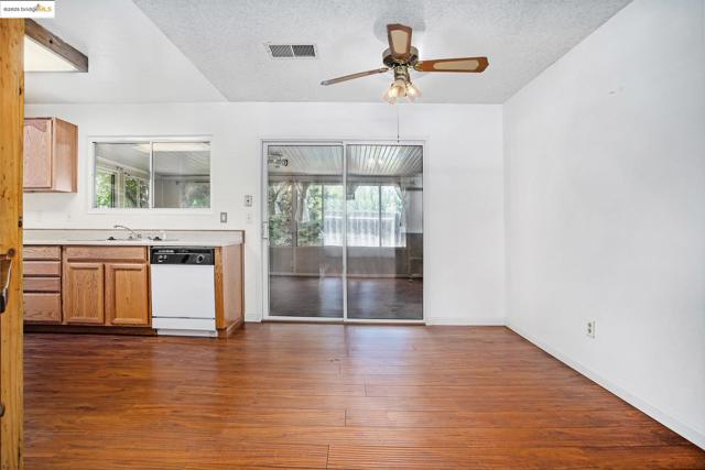 Kitchen with plenty of natural light, light countertops, dark wood-type flooring, dishwasher, and a textured ceiling