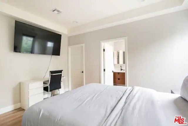 Bedroom #1 with a walk-in-closet, TV, and work space
