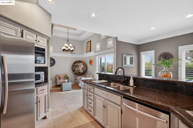 Kitchen featuring appliances with stainless steel finishes, dark stone countertops, pendant lighting, recessed lighting, and light tile patterned floors