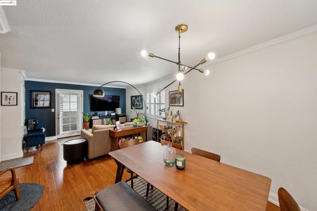 Dining room featuring ornamental molding, wood finished floors, healthy amount of natural light, and a chandelier