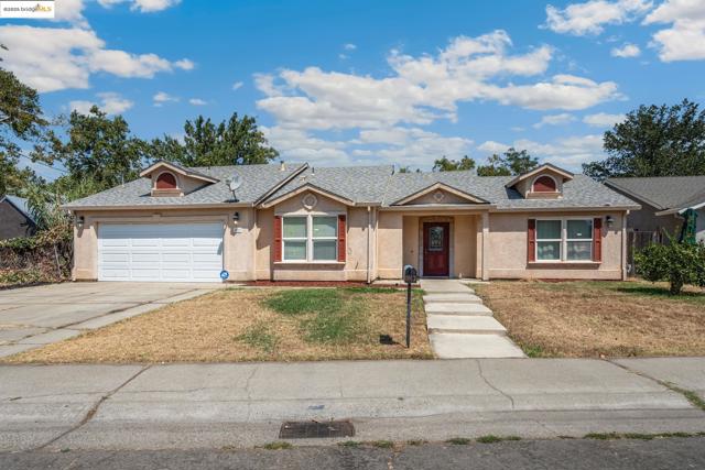 Ranch-style house featuring stucco siding, a garage, concrete driveway, and a front yard