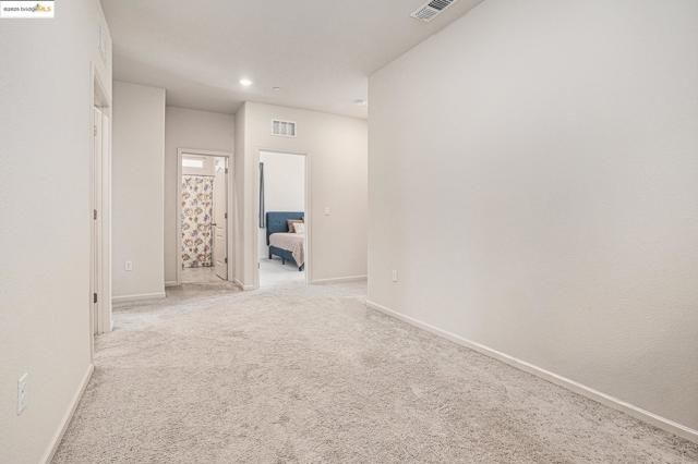 Carpeted empty room with baseboards and recessed lighting