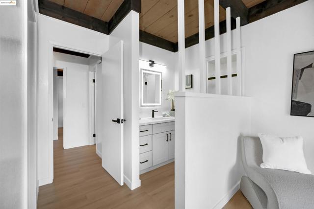 Hall with a wood ceiling with exposed beams and light wood-style floors