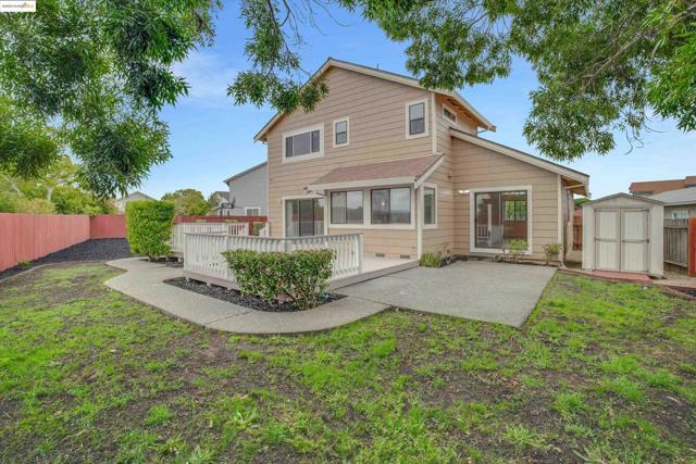 Back of house featuring a storage shed, a fenced backyard, a patio area, and a deck