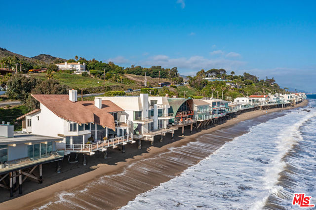 Prestigious 24-hour guard gated Malibu Cove Colony Celebrity Beach house located on rare 70 ft of prime oceanfront. The unique design is an architectural masterpiece by Harry H. Gesner. There are spectacular views from nearly every living space. The private gated courtyard entry features a BBQ cooking area and a large built-in sitting area encircling an outdoor fire pit.  The glass front door leads to the two-story living room with walls of glass & dramatic vaulted ceilings which allow for an abundance of natural light. The open kitchen flows to the family room which extends out to a private deck. The first floor is comprised of a den/office, a large sitting room with a fireplace and a full bar with an additional living area. Upstairs, the sweeping staircase leads up to all 3 bedrooms including a luxurious primary suite with large walk-in closet, fireplace, spa-style bathroom & large private deck. Located moments from Nobu, Soho-House, Malibu Pier, world-class beaches and hiking trails. Adjacent property coming soon on the market.
