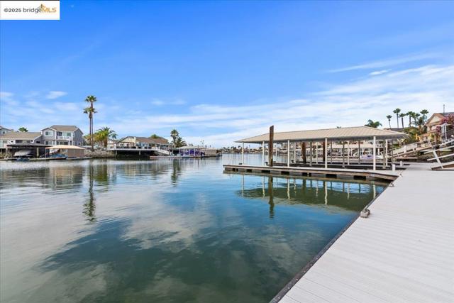 Dock area with a water view, a residential view, and boat lift