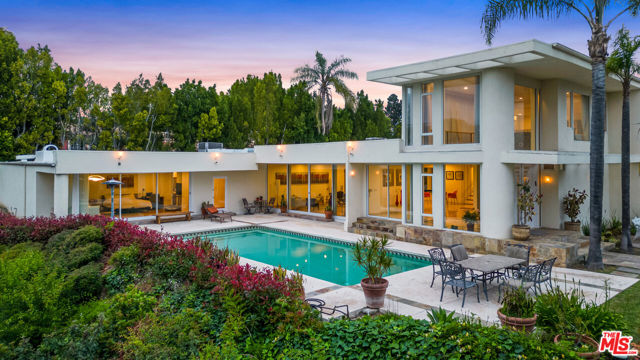 1030 Della Drive Beverly Hills, California Nestled in the prestigious city of Beverly Hills neighborhood, just north of Sunset Boulevard, rests a gated exquisite property on a tranquil promontory on cul-de-sac street. This luxurious residence offers the perfect blend of privacy and serenity and an oasis of tranquility in the heart of the bustling city minutes from premiere shopping, restaurants and entertainment. The house exudes timeless elegance with its captivating mid-century design, characterized by clean lines and a harmonious integration of indoor and outdoor spaces. As you step inside, you are greeted by soaring high ceilings that create an immediate sense of grandeur and openness. Natural light pours in through expansive windows, illuminating the spacious rooms and creating a seamless connection between the interior and the lush outdoor surroundings. This property is truly a sanctuary, providing the ideal backdrop for relaxation and luxurious living in one of the most coveted neighborhoods in the world.