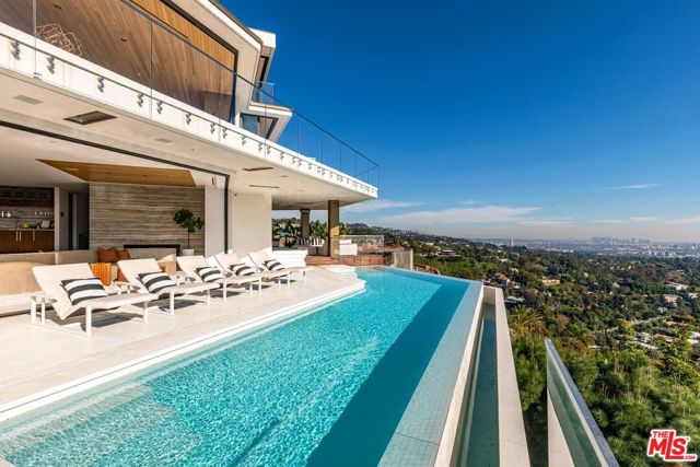 A warm organic modern estate designed by Disco Volante. Standing regally at the end of a cul-de-sac on one of the best promontories in Beverly Hills with unobstructed views of the entire city from DTLA to the ocean. Minutes away from The Beverly Hills Hotel & Rodeo Drive. Breathe California in this ultra-luxurious, 3-story modern with open floor plan & wall-to-wall sliders providing the quintessential SoCal indoor-outdoor lifestyle. A luxurious master suite includes an oversized balcony, walk-in closet & soaking tub surrounded by retractable doors. Lower level entertainer's paradise includes a home theater, custom bar, outdoor kitchen, firepit lounge & infinity pool. Architecture by the Dutch design masters at Unknown, every square inch was crafted to perfection using only top-of-the-line materials sourced from around the world. A truly magnificent offering & exclusive opportunity to own an estate of modern elegance in the most prestigious zip code in the world.