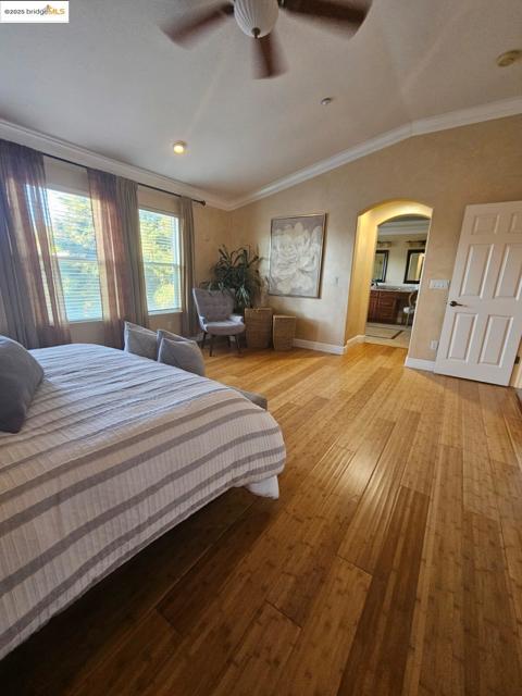 Bedroom with crown molding, arched walkways, hardwood / wood-style flooring, ceiling fan, and recessed lighting