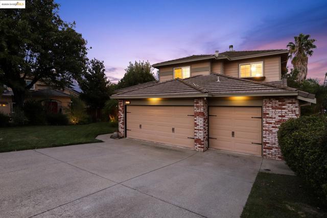 Traditional-style home with brick siding, a garage, a front yard, and driveway
