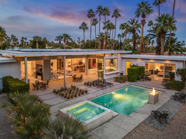 Luxury redefined in Palm Springs: This 2017 masterpiece in Old Las Palmas offers 5,000 sq ft of elegance with dual primary suites and two guest suites. The grand entrance leads to a living space with a retractable 40-foot door, dual fireplaces, and stunning views. Step outside to a covered patio, infinity spa, fire pit, and waterfall, where countless days and evenings will be spent entertaining and relaxing. The kitchen boasts Wolf appliances, two island counters, a butler's pantry, a marble backsplash, and panoramic views. A private primary suite rivals a 5-star hotel, and a second suite provides privacy. Gated for seclusion, yet opens to expansive West and South-facing views. Your dream home awaits - embrace luxury living!  Some furnishings may be available for sale outside of escrow. Yard sculptures are included.Solar system owned, not leased.