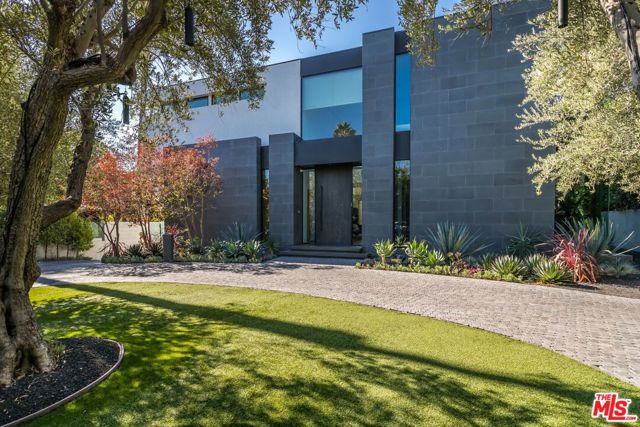 809 N Rexford Drive Beverly Hills, California In the prestigious Beverly Hills Flats, this show-stopping contemporary residence invigorates the soul the minute one meets its magnificent light-filled 2-story entry. The airy floor plan and fluid spacing of indoor/outdoor environments provide the perfect canvas for its awe-inspiring modern wall art, furniture and suspended light fixtures. Through glass sliders an oversized covered patio with ceiling heaters features a fire pit and a sleek bar extending from the living room; step-down terraces lead to an expansive pool, outdoor bar and a guesthouse with a yoga studio. A gleaming Boffi custom kitchen built for culinary art with rich Carrera marble flooring, black basalt countertops and Gaggenau appliances. Artistry continues in the upper level with a lavish master bedroom suite, secondary bedrooms, and an extraordinary sundeck celebrating sunlight and color. Lower level features a theater with professional grade leather seating. Seize this rare gem in the Flats.