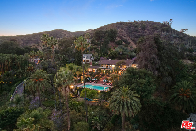 A residence of exquisite style and exceptional privacy, this remarkable compound sits at the top of a winding drive on approx. 6.5 acres of gorgeous landscaping, mature trees, and Hollywood sophistication. Gated enclave is both private sanctuary and distinguished setting for lavish entertaining. Just four previous owners: Dustin Farnum, star of DeMille's "Squaw Man"; Mark Hellinger, writer/producer whose short story gave rise to Bogart/Cagney film "The Roaring Twenties"; Gail Patrick,  executive producer of Perry Mason series and one of the first and most successful female producers in Hollywood; and director Taylor Hackford. Fabulous residence combines tranquility, privacy and convenience. Spacious, elegant main residence has swimming pool, wide terrace for lounging, dining, entertaining. Separate 3-bedroom guest house plus 5-car garage with office and apartment above. Refined and comfortable, with gorgeous city lights views, manicured gardens, and beautifully detailed interiors.