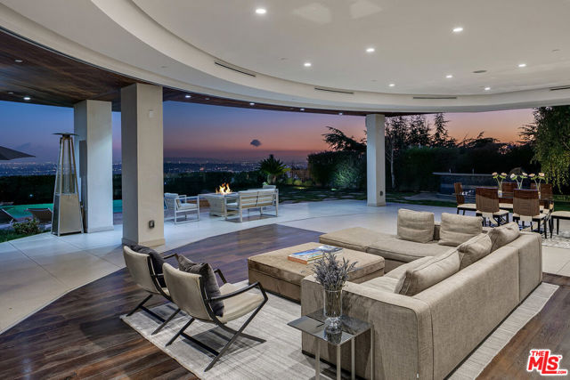 2235 HERCULES Drive Los Angeles, California Recently constructed from the ground up in 2013, this 5 bedroom and 7 bath modern architectural home welcomes you to Mount Olympus located in Hollywood Hills. This neighborhood gives you the convenience of its proximity to downtown LA and Van Nuys airport while also offering the security and privacy from the bustling city life. Upon entrance you are greeted by a sleek modern spiral staircase followed by a custom-circular indoor-outdoor seating area fitted with a gas fire pit, and wrap-around retractable floor to ceiling windows that offer a 180 degree panoramic view from downtown LA to the Pacific Ocean. This view is accompanied by the meticulously manicured backyard and an infinity pool and spa as well as an outdoor grilling area that overlooks the gorgeous mountainside that this home sits on. The first floor has a home theater equipped with a surround sound stereo system and a top of the line projector perfect for personal entertainment or for hosting. The sleek modern European kitchen is accompanied by state of the art appliances and a center island with an integrated stovetop, making this kitchen a perfect fit for home cooked meals or catering. This home has unrivaled hosting abilities with its bar area and seating in the first floor accompanied with the private wine cellar in the lower floor that is accessed by a luxurious glass elevator. The lower floor also boasts an impressive 5 car subterranean garage that is a perfect fit for automobile enthusiasts. After a long busy day, you can be sure to relax in your own master suite on the second floor alongside its private grand balcony, two sided fireplace with reflective privacy glass, and a massive walk-in closet. The master bathroom is dressed in floor to ceiling marble and privacy windows offering a magnificent view for when you wish to unwind in its modern floating tub or its rain-steam shower. Come down to Mount Olympus to enjoy the coveted LA lifestyle and weather in a home perfectly designed to grant your every wish.
