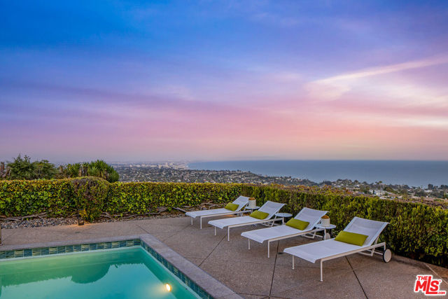 Featuring quintessential Mid-Century Modern design and breathtaking unobstructed ocean and city views, this single-story home on famed Lachman Lane in the Pacific Palisades is a testament to classic architecture, clean lines, and indoor-outdoor living. Recently renovated by a master developer & architect duo as their personal residence, the home features a luminous open floor plan, hardwood floors, walls of glass, and imported finishes and materials. A grand entry foyer leads you into the open-concept living area showcasing a custom B&B Italia bookcase & marble fireplace. The chef's kitchen features premium stainless steel appliances and an eat-in island ideally situated off the family room, breakfast area, and formal dining area. Exhibiting a perfect floor plan with four spacious and luxuriously appointed bedrooms, the home is a perfect pied-a-terre or family home for the most discerning buyer. The backyard is a true oasis with a sparkling pool, outdoor kitchen, covered dining, and outdoor entertaining areas, set against the backdrop of the panoramic Pacific Ocean, Queen's Necklace, Catalina, Santa Monica, and even DTLA views. Do not miss the rare opportunity to own this completely turn-key, single-level mid-century jewel featuring some of the most breathtaking views of the So-Cal coastline just minutes away from the finest dining, entertainment, and leisure venues such as Palisades Village, Brentwood, and Malibu.
