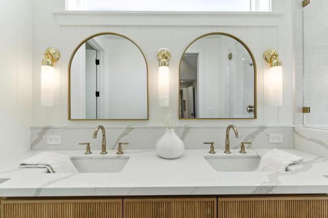 Dual vanity bath with wood cabinetry and stylish mirrors. 