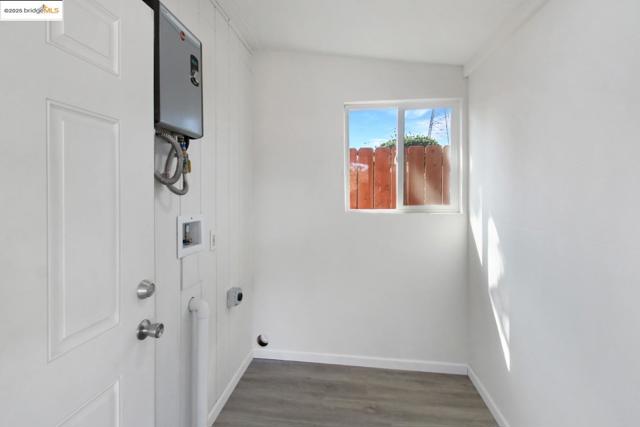 Laundry room featuring wood finished floors and washer hookup