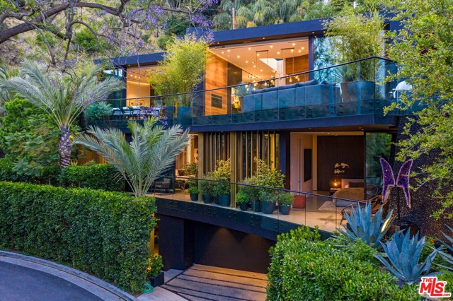 8517 FRANKLIN Avenue Los Angeles, California A bold & innovative departure in new construction whose inimitable style will set a new benchmark for design. Resort-like estate set above the street w/ 120' driveway. Incredible quality/attention to detail w/ rich textures/finishes including luxurious wall coverings, marbles, oak paneled walls & walnut cabinetry. Main level - 13' ceilings & open flr plan w/ liv/din/bar spaces & showroom kitch all open to outdoors. The master suite is reminiscent of a 5-star hotel w/ sit. area, 2-way frplc, custom white oak cabinetry dressing rm & spectac. bath all w/adj outdoor area. 2 addt. en-suite bdrns w/ custom finishes on this level. Entertainment level is part lounge/nightclub/sports bar & includes theater, wine rm & separate entry. A separate space can be office/gym/studio or 4th bdrm. Vantage automation system & surround sound. Serene & tranquil grounds w/ outdoor liv/din area w/ built-in barbeque, zero-edge pool & spa & peaceful water wall overlooking commanding views of the city lights.