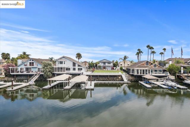 Dock area with boat lift, a residential view, and a water view
