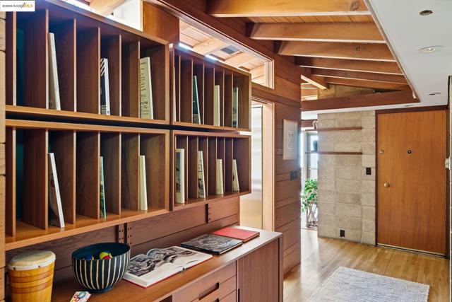 Miscellaneous room with wooden walls, light wood-style flooring, wood ceiling, and a desk