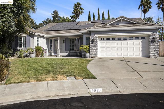 Sought after 1-level home featuring a covered porch, a front lawn, brick siding, concrete driveway, and stucco siding