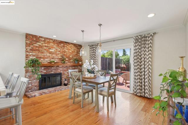 Dining room with recessed lighting, ornamental molding, wood finished floors, and a fireplace