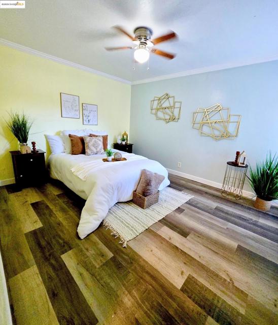 Bedroom with crown molding, wood finished floors, and ceiling fan