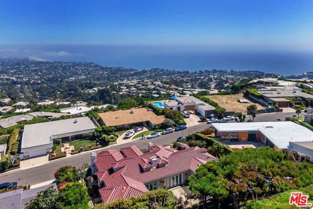 16669 Charmel Lane Pacific Palisades, California Beautiful ocean and canyon views from this custom Steve Stilwell signature built home. Constructed with the finest materials in 2003, this elegant home features Travertine tiled floor, a stone-faced fireplace, and floor to ceiling windows with gorgeous views from the family room. The open floor plan flows with natural light and into the backyard with beautiful vegetation creating that ideal California living. The kitchen is perfect for hosting with an over-size island as well as stainless steel Wolf and Sub-Zero appliances, maple cabinetry, and a half-circle breakfast nook. For all the wine enthusiasts a custom CellarMasters wine cellar. The master bedroom showcases a fireplace, a spacious master bathroom with onyx accents, and extravagant shower with mountain views. Every bedroom is complete with French doors opening to the backyard. This gated home feels like your own private oasis conveniently located within moments to the new Palisades Village and ocean.