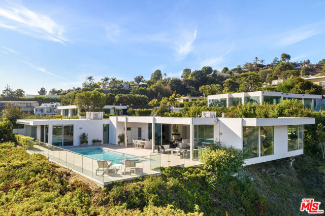 1476 Carla Beverly Hills, California Superb Mid-Century Trousdale gem with outstanding views. Walls of glass are situated to capture both city and westerly ocean views. Move-in condition and recently renovated. Period limestone floors interior and exterior. Primary ensuite bedroom with spectacular city views, guest bedroom ensuite. Staff bedroom and bath. There is a den/office with a bathroom that doubles as a pool bath. The remodeled kitchen has chef quality equipment. There is a dedicated dining area and separate breakfast area. Outside is the inviting and private pool and spa facing the views. Exterior seating and dining under roof makes this feel like an additional room. This home has privacy and style and is a Trousdale Best Buy. Please note there are only 2 bedrooms plus staff.