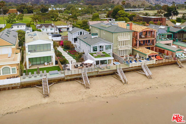 Exceptional opportunity on the sand inside the exclusive Malibu Colony guard gates. Grand scale throughout with beamed ceilings and lots of light. Beautifully appointed living room and family room both open up to the expansive outdoor entertaining space with a sunken jacuzzi tub just steps from the sand. The chef's kitchen boasts a large center island and a sunny breakfast area. Gracious primary suite with high ceilings, sitting area, and private oceanfront deck featuring beautiful ocean views up and down the coast. The primary bathroom includes dual vanity's with a massive rain shower and two additional bedroom suites on the second level. Off the courtyard is a separate guest house with a living room, one-bedroom suite, and lofted gym. Offering absolute privacy and security, this is the ultimate retreat moments from Malibu's renowned shopping and dining.