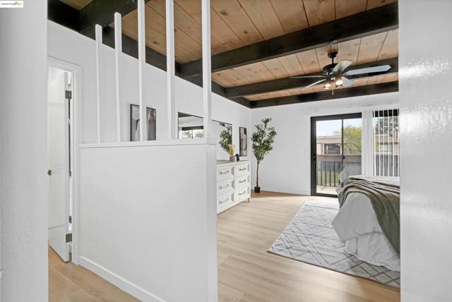 Bedroom featuring a wooden ceiling with exposed beams, light wood-style floors, access to outside, and ceiling fan